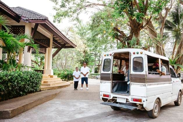 Male and female owners looking at tourists sitting inside van at resort during vacation Thailand, Ko Lanta, model released, property released Copyright: xMaskotx , MA100505 MA100505