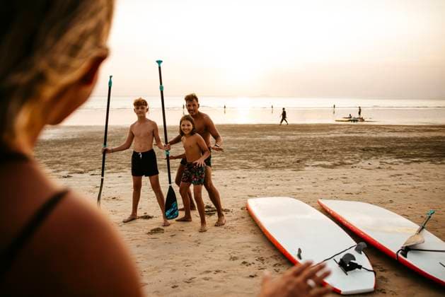 Female instructor giving course of paddleboarding to tourists at beach during sunset Thailand, Ko Lanta, model released Copyright: xMaskotx , MA100544 MA100544