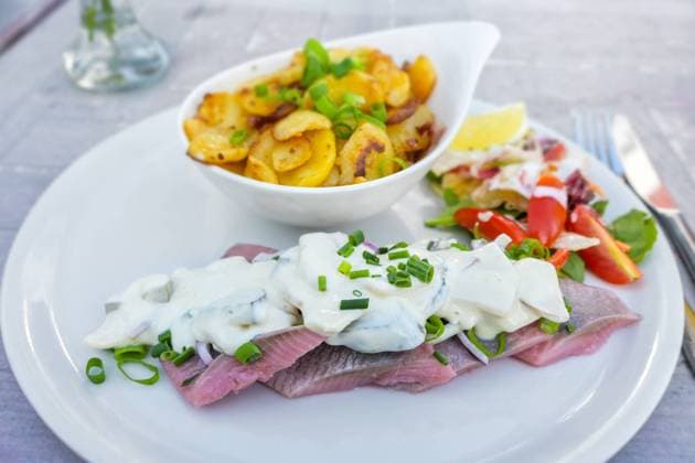 Matjes or soused herring, a mild salt fish with cream sauce containing onions, gherkins and apple, served with bratkartoffeln (German fried potatoes) and salad, selected focus Matjes or soused herring, a mild salt fish with cream sauce containing onions, gherkins and apple, served with bratkartoffeln (German fried potatoes) and salad, selected focus, narrow depth of field Copyright: xZoonar.com NarenxWinterx 19243454