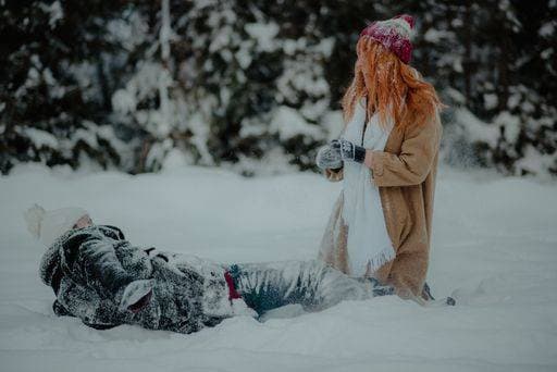 A side view of a ginger-haired woman and her boyfriend laughing while falling in the snow with completely snow-covered clothes *** einer Bordwand Ansicht des einer Ingwer haired Frau und her boyfriend lachend wärend fallend ÊIn der Schnee mit Völlig Schnee Gedeckter Klamotten 1582647 ,model released, Symbolfoto