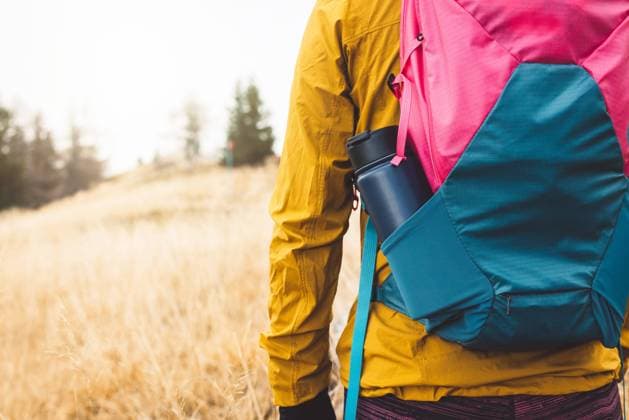 Close up view from the back unrecognizable woman with a pink and blue backpack with thermo flask sticking out of the side pocket Back view of unrecognizable woman with a colorful blue and pink backpack with a water thermo flask in the side pocket, sticking out. ,model released, Symbolfoto Copyright: xZoonar.com ZigaxPlahutarx 19539196 ,model released, Symbolfoto ,property released