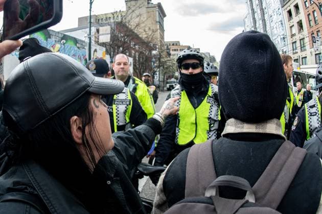 April 5, 2023, Vancouver, British Columbia, Canada: A demonstrator swears at Vancouver police officers on Hastings Street in Vancouver, Canada, as police and city crews remove a homeless encampment April 5. The City of Vancouver requested a heavy police presence for the safety of crews clearing the tents, temporary structures and personal effects of homeless residents who have camped on the sidewalk for about eight months, sometimes blocking the entrances of businesses and residencies. The move follows the closure of encampments in public parks two years ago at the onset of whatâ€⠢s now Canadaâ€⠢s worst affordable housing crisis. Motivating the latest sweep, officials cited a spike in fires, assaults, robberies and other public s - ZUMAb217 20230405_zip_b217_006 Copyright: xQuinnxBenderx