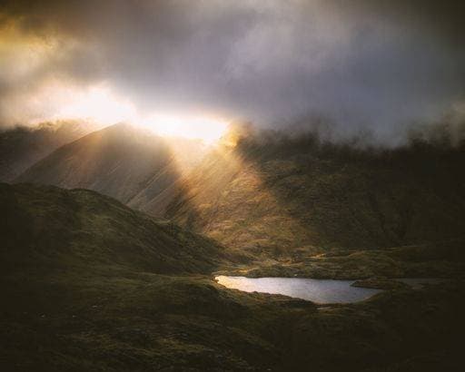 RECORD DATE NOT STATED The shafts of sunlight breaking through the clouds near mountain tarn in the Lake District, England *** der Schächte des Sonnenlicht Brechung durch der Wolken nahe Berg tarn ÊIn der See District, Englands 10325831