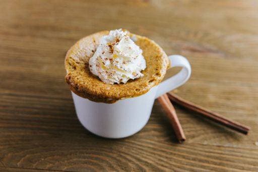 RECORD DATE NOT STATED A closeup of an appetizing Pumpkin Spice Mug Cake surrounded by cinnamon rolls on the table *** einer closeupe des An&Verkauf appetitlich Kürbis Gewürz Mug Kuchen umgeben indem Zimt Rollen am der Tisch 10474820