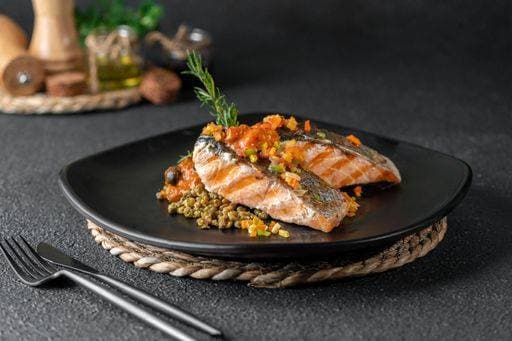 RECORD DATE NOT STATED A closeup of a plate of grilled salmon with beans garnished with rosemary on the table *** einer closeupe des einer Teller des gegrillt Lachs mit Bohnen garniert mit Rosmarin am der Tisch 10588189