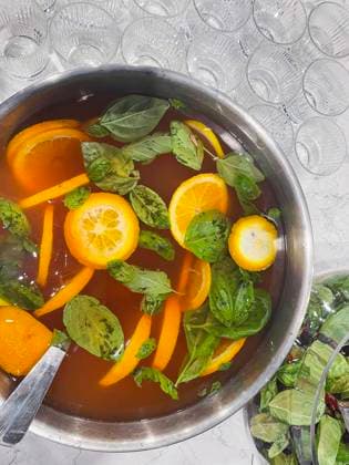 Punch large bowl with oranges and mint. Boiled citrus juice. Drink with a variety of fruits close up. Orange alcoholic cocktail. Empty glasses on the background table. Punch large bowl with oranges and mint. Boiled citrus juice. Drink with a variety of fruits close up. Orange alcoholic cocktail. Empty glasses on the background table. Lifestyle and party concept. Copyright: xZoonar.com DashaxPetrenkox 19832560