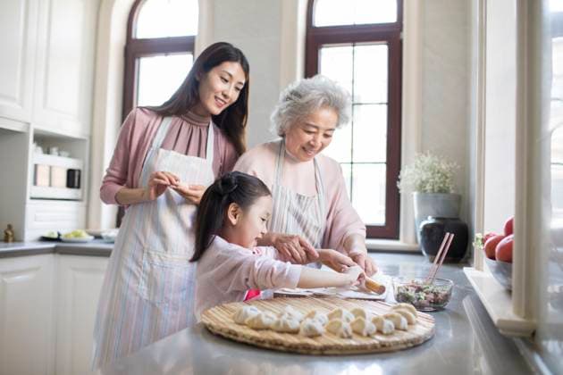 RECORD DATE NOT STATED Cheerful Chinese family making dumplings in kitchen Beijing China Copyright: xLanexOateyx bji05410147