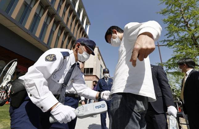 News Themen der Woche KW16 News Bilder des Tages Japan PM stump speech in Wakayama A police officer checks a visitor at the venue of a stump speech by Japanese Prime Minister Fumio Kishida in Wakayama on April 22, 2023, a week after an explosive device was thrown at him at a fishing port in the western Japan city.  A14AA0001419188P