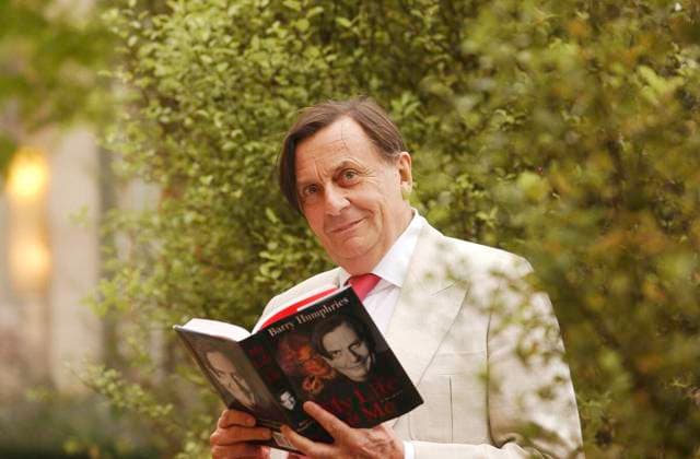 BARRY HUMPHRIES OBIT, *FILE* Entertainer Barry Humphries poses for a photograph with his book My Life as Me in Melbourne, November 25, 2002. Entertainer Barry Humphries, who brought to life Dame Edna Everage and Sir Les Patterson, has died at the age of 89 in a Sydney hospital surrounded by family. ( NO ARCHIVING, EDITORIAL USE ONLY, NO USE IN BOOKS WITHOUT CONSENT MELBOURNE VIC AUSTRALIA  Copyright: xJOExCASTROx 20230422001789503133