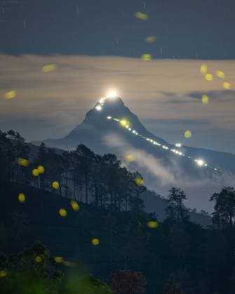 IMAGO Nature: Unsere Erde, Lichtverschmutzung in den Nächten bedroht Glühwürmchen-Populationen Adam s Peak, A World Heritage Site In Sri Lanka A firefly flies in front of Adam s Peak mountain in Hatton, Sri Lanka, on April 22, 2023. Sri Pada, or Adam s Peak, is an ancient pilgrimage site that has long attracted thousands of pilgrims from all faiths. This conical mountain is 7,360 feet (2,250 meters) high, soaring clear above the surrounding mountain ranges. The mountain is located in the southern reaches of the Central Highlands in the Ratnapura District and Nuwara Eliya District of the Sabaragamuwa Province and Central Province, lying about 40 km northeast of the city of Ratnapura and 32 km southwest of the city of Hatton. The surrounding region is largely forested, with no mountains of comparable size nearby. The region along the m  Copyright: xThilinaxKaluthotagex originalFilename: kaluthotage-notitle230422_npEut.jpg