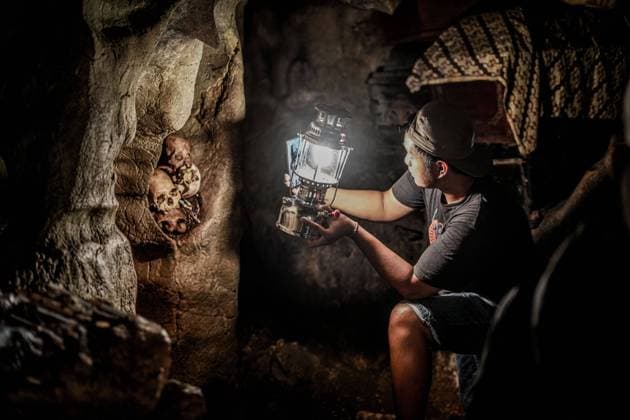 IMAGO Cultures of the world, Toraja Volk in Indonesien April 23, 2023, North Toraja, South Sulawesi, Indonesia: A tour guide carries a flashlight to show several human skulls that have long been buried in caves at the Londa cemetery complex, North Toraja. During the Eid al-Fitr holiday, many tourists come to this place. North Toraja Indonesia - ZUMAb223 20230423_zip_b223_003 Copyright: xHerwinxBaharx