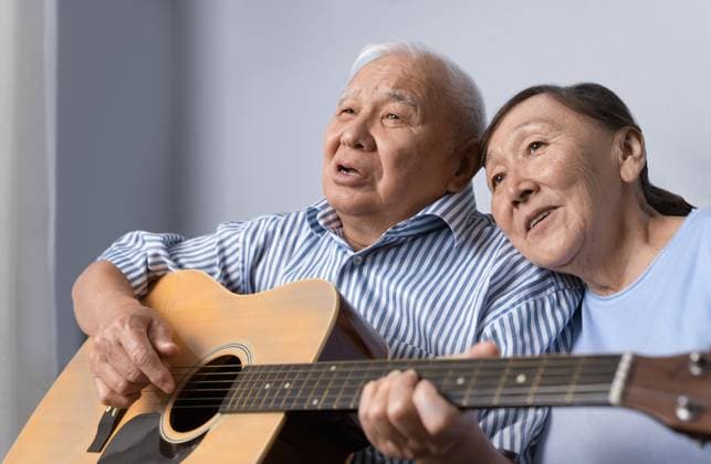 Senior man playing acoustic guitar and singing with his wife at home Florida City, Florida, United States CR_ARZH230321-1150014-01 ,model released, Symbolfoto