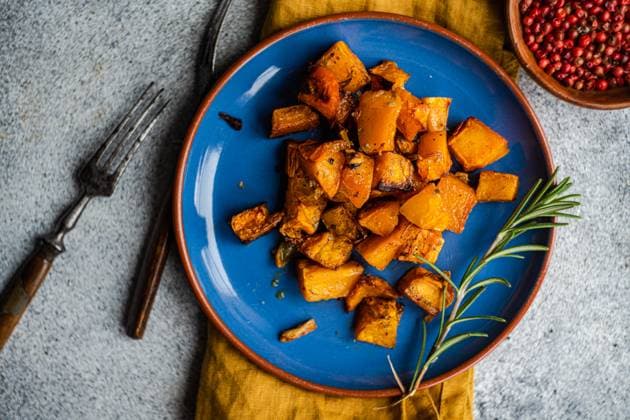 Baked spicy pumpkin cubes served on blue ceramic plate on the table AnnaBogush_ID13421_408786_002 Copyright: xAnnaxBogushx Model Released