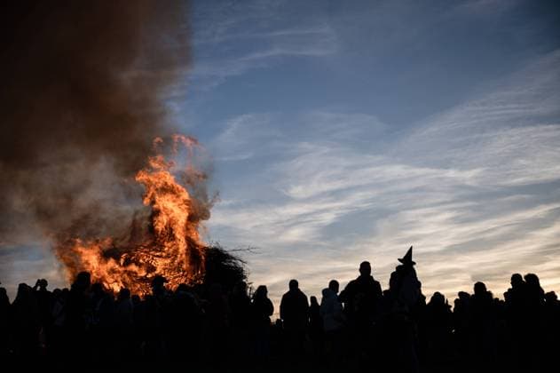 30.04.2023 Weimarer Land - Bergern: Ein Mädchen als Hexe verkleidet mit einem Hexenhut zeichnet sich als Silhouette vor einem traditionellen Feuer zur Walpurgisnacht ab. *** 30 04 2023 Weimarer Land Bergern A girl dressed as a witch with a witchs hat stands out as a silhouette in front of a traditional fire for Walpurgis Night