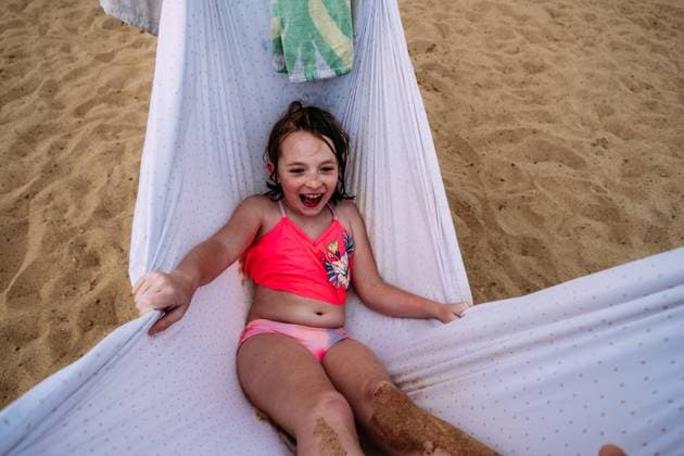 Creative Highlights Symbolbilder Sandy young girl swinging in hammock on beach Denver, Colorado, United States CR_JEMI230316E-1137784-01 ,model released, Symbolfoto