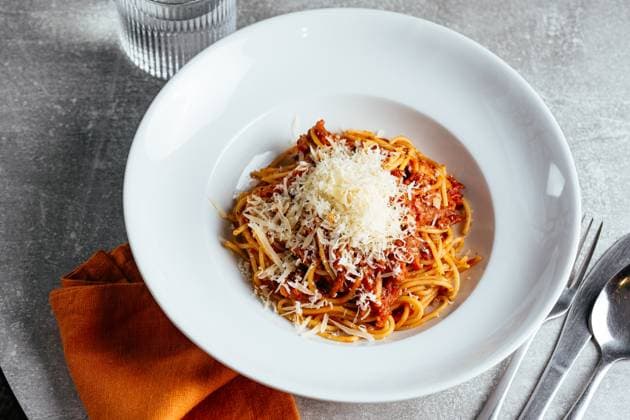 pasta bolognese in a white plate on a light table in a restauran Washington, District of Columbia, United States R_KUAL230306D-1146753-01