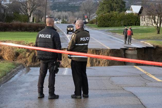 May 1, 2023, BAIE SAINT-PAUL, PQ, CANADA: Two provincial police officer secure a road damaged from flood waters on Monday, May 1, 2023 in Baie Saint-Paul, Quebec. In Baie-St-Paul, Que., around 90 kilometres northeast of the provincial capital, the mayor declared a state of emergency due to heavy rains that washed away roads and isolated homes. BAIE SAINT-PAUL CANADA - ZUMAc35_ 20230501_zaf_c35_088 Copyright: xJacquesxBoissinotx