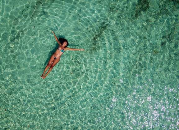 Creative Highlights Symbolbilder Aerial view of Young adult Female floating on crystal turquoise water. Jervis Bay, New South Wales, Australia R_BUYH230228-1137320-01 ,model released, Symbolfoto