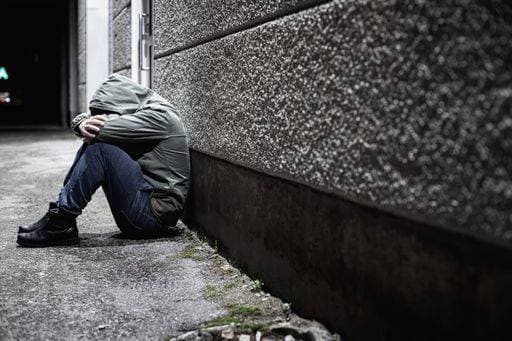 A man sitting down depressed in a dark alleyway at night with his head buried in his arms *** einer Mann sitzend nieder depressiv ÊIn einer dunkle Alleenstraße im Nacht mit seinem Kopf beigesetzt ÊIn seinem Arme 3581493