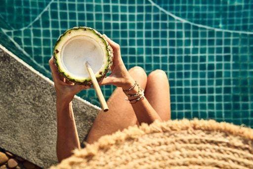 RECORD DATE NOT STATED A top view of a woman having a pineapple drink at the pool *** einer Spitze Ansicht des einer Frau habend einer Ananas trinken im der Bassin 3670018