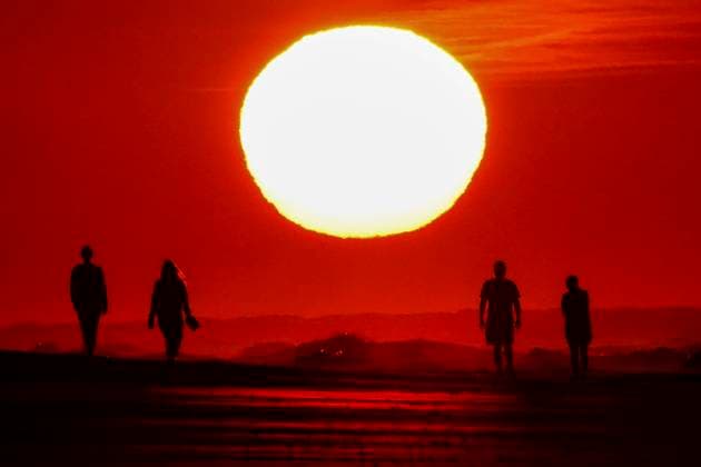 News Bilder des Tages May 7, 2023, Isle of Palms, SC, United States of America: People are silhouetted as they walk along the beach toward a sunrise appearing as a giant ball, May 7, 2023 in Isle of Palms, South Carolina. The Charleston area is experiencing unusually cool and dry weather for May as the jet stream dipped south bringing cooler Canadian air to the southeastern United States, but is expected to return to the high 80Ã¢â‚¬â ¢s later in the week. Isle of Palms United States of America - ZUMAe02_ 20230507_zaf_e02_004 Copyright: xRichardxEllisx