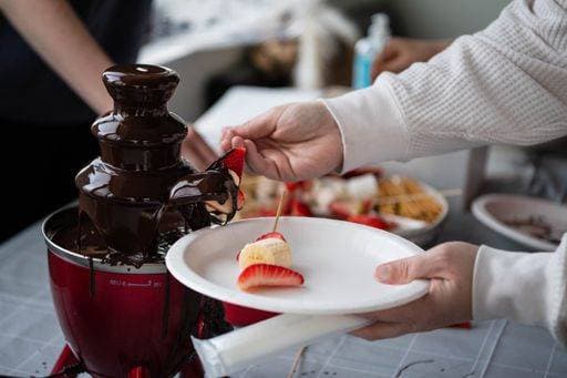 RECORD DATE NOT STATED Anonymous person dipping fresh fruits strawberries and bananas into a delicious chocolate fondue fountain at a party and a celebration *** anonym person eintauchendes Frisch Früchte Erdbeeren und Bananen hinein einer Köstlich Schokolade fondue Fontäne im einer Fest und einer Feier 4837074