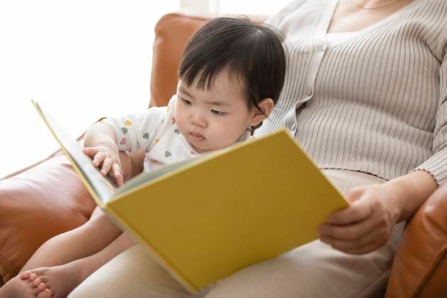 Happy Chinese grandmother and baby reading picture book Beijing China Copyright: xLanexOateyx bji06710088