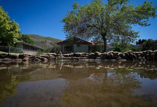 May 14, 2023, CACHE CREEK, BC, CANADA: Water is pumped out from a flooded home near the Bonaparte River as sandbags line a sidewalk in Cache Creek, B.C., on Sunday, May 14, 2023. Environment Canada says unseasonably hot temperatures in British Columbia will persist over the coming days, with special weather statements warning of high river streamflows due to melting snow in hard-hit communities in the province s interior. CACHE CREEK CANADA  - ZUMAc35_ 20230514_zaf_c35_105 Copyright: xDarrylxDyckx