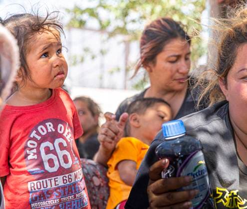 May 10, 2023, Juarez-El Paso Border, Texas, USA: Migrants wait to be processed at gate 40 of the border wall after having crossed the Rio Grande from Ciudad Juarez in hopes of turning themselves in with the intention of seeking asylum. Many migrants waited without shelter for lengthy periods of time. After six days outside, under extreme heat during the day, freezing temperatures at night and fierce sandstorms, women and small children crowded together under the shade of two trees. Juarez-El Paso Border USA - ZUMAing 20230510_new_s241_027 Copyright: xBelindaxSoncinix