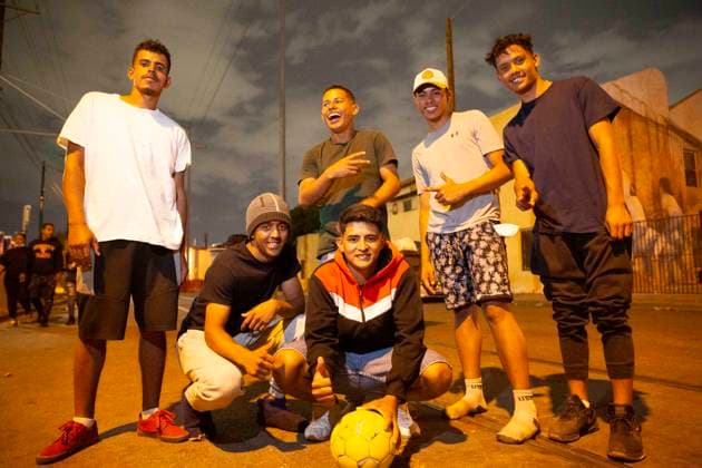 May 13, 2023, El Paso, Texas, USA: A group of mostly 19-year-olds from Venezuela and Columbia, who have been living on the sidewalk outside Sacred Heart Catholic Church since crossing the border from Juarez, Mexico this week, after Title 42 was lifted. When someone gave them a soccer ball earlier in the day, they played for six hours on the closed-off street. It almost makes us feel like we™re home, one of them said in Spanish. All of them had been working in their countries since they were young in order to support their families. They want to work again now that they are in the US, but are not permitted to work while awaiting their asylum hearings, which could take more than a year. Left to right: WILME, CARLOS, SHRISTIAN (standin - ZUMAs li 20230513_new_s241_040 Copyright: xBelindaxSoncinix