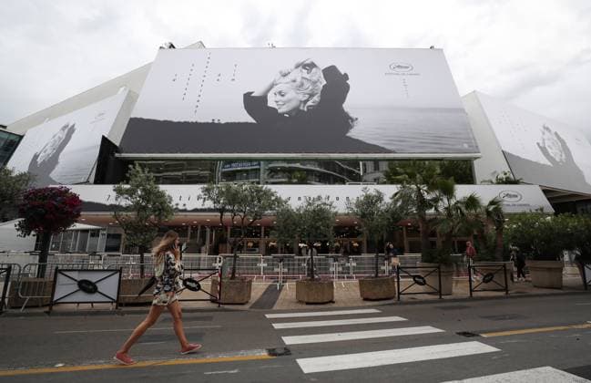 (230516) -- CANNES, May 16, 2023 -- A woman walks past a huge poster of the 76th edition of the Cannes Film Festival outside the Palais du Festival in Cannes, southern France, May 15, 2023. The film festival will be held from May 16 to 27, 2023. ) FRANCE-CANNES-FILM FESTIVAL-PREPARATION GaoxJing 