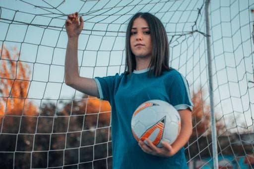 RECORD DATE NOT STATED A vertical shot of a beautiful female football player posing on the background of a football net *** einer hoch erschossen des einer Schönes weiblich Fußball Spielender posierend am der Hintergrund des einer Fußball Netto 6783403 ,model released, Symbolfoto