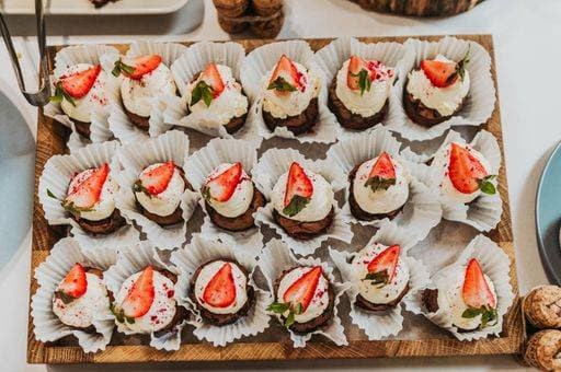 RECORD DATE NOT STATED A top view of freshly baked chocolate cupcakes with cream and strawberries *** einer Spitze Ansicht des freshly gebacken Schokolade Törtchen mit Creme und Erdbeeren 7166161