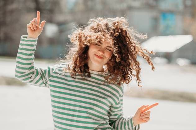 Smiling woman with curly hair dancing at sunny day model released, Symbolfoto, ANAF01330
