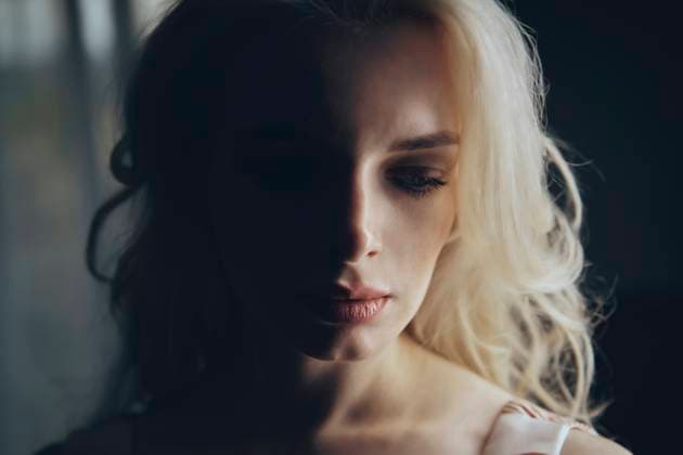 Depressed blond woman in darkroom model released, Symbolfoto, AZF00519