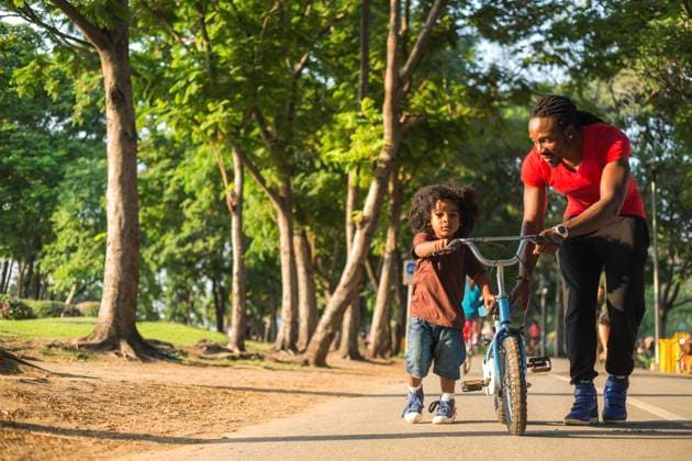 Father wheeling bicycle with son on footpath at park model released, Symbolfoto, IKF00621