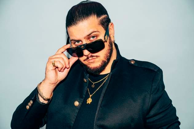 MR_ID13306_13123_JuanCarrasco.jpg Portrait of stylish young bearded male model in black jacket with accessories and trendy haircut touching sunglasses against blue background in studio, Model released JoseLuisCarrascosa_ID13306_405780_024 Copyright: xJosexLuisxCarrascosax MR