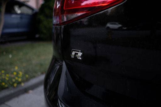 RECORD DATE NOT STATED A closeup shot of the Volkswagen Golf R Emblem on Black Vehicle *** einer closeupe erschossen des der Volkswagen Golfen R&B Hoheitszeichen am Schwarz Fahrzeug 7707934