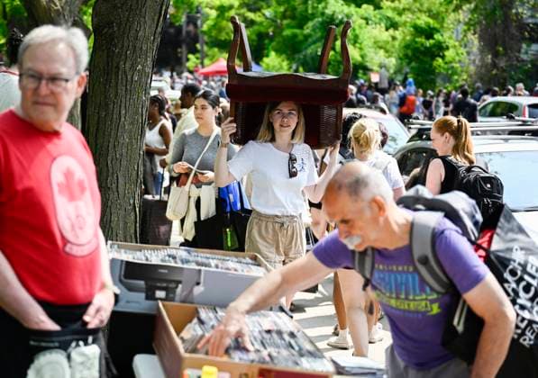May 27, 2023, Ottawa, ON, CAN: Erica Phillips balances an armchair that she bought at the Great Glebe Garage Sale as she passes other sellers tables, in Ottawa, on Saturday, May 27, 2023. The community event draws thousands of people to the Glebe, one of OttawaöÄÃ s heritage neighbourhoods, with vendors donating a percentage proceeds to the Ottawa Food Bank. Ottawa CAN - ZUMAc35_ 20230527_zaf_c35_015 Copyright: xJustinxTangx