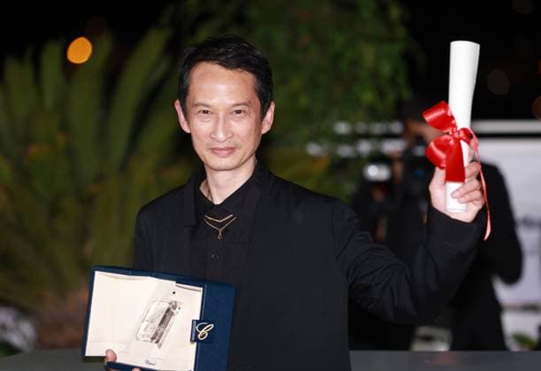 (230528) -- CANNES, May 28, 2023 -- Vietnamese-French director Tran Anh Hung poses with the trophy during a photocall after he won the Best Director award for the film La Passion de Dodin Bouffant (The Pot-au-Feu) during the closing ceremony of the 76th edition of the Cannes Film Festival in Cannes, southern France, May 27, 2023. ) FRANCE-CANNES-FILM FESTIVAL-AWARDS GaoxJing 