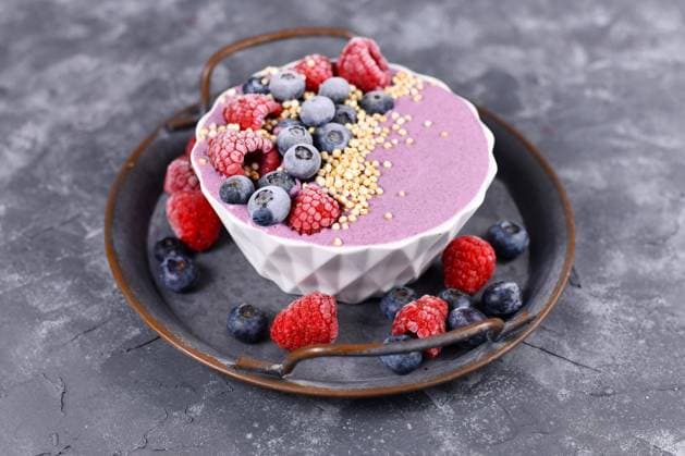  Frucht Smoothie Bowl mit rosa Joghurt, dekoriert mit gesunder Himbeere, Blaubeere und gepufftem Quinoa Korn auf Eisentablett *** Fruit smoothie bowl with pink yogurt decorated with healthy raspberry, blueberry and puffed quinoa grain on iron tray Copyright: imageBROKER/Firn ibxmob09305167.jpg