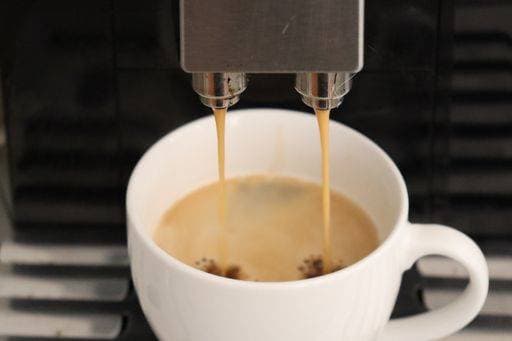 A closeup of a coffee machine pouring coffee in a white cup *** einer closeupe des einer Kaffee Maschine einschenkend Kaffee ÊIn einer weiß Tasse 5054005 RECORD DATE NOT STATED