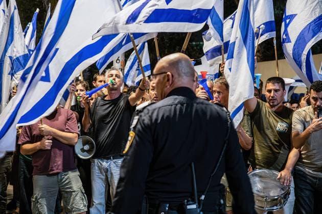 News Themen der Woche KW22 News Bilder des Tages June 3, 2023, Hadera, Israel: An Israeli police officer stands in front of protesters holding Israel flags during the demonstration. Israeli police officers push back protesters against the judicial reform who demonstrated in front of Hadera police station in support of protesters who were arrested next to Prime Minister Benjamin Netanyahu™s house in Caesarea. Hadera Israel - ZUMAs197 20230603_zaa_s197_007 Copyright: xMatanxGolanx
