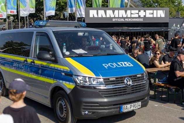 A police car drives past fans standing in line in the heat at the Official Merchandise Stand at the Rammstein concert by Till Lindemann at the Olympiapark in Munich Germany Date 07 06 2023