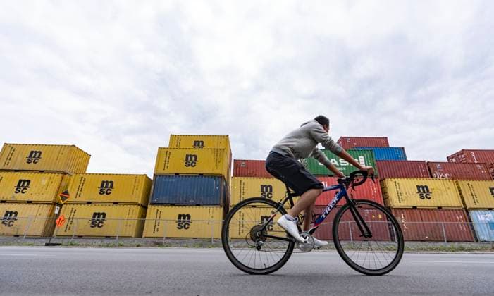 June 9, 2023, MONTREAL, PQ, CANADA: A cyclist travels past stacked shipping containers at a transloading and container storage facility in Montreal, Friday, June 9, 2023. MONTREAL CANADA  - ZUMAc35_ 20230609_zaf_c35_088 Copyright: xChristinnexMuschix