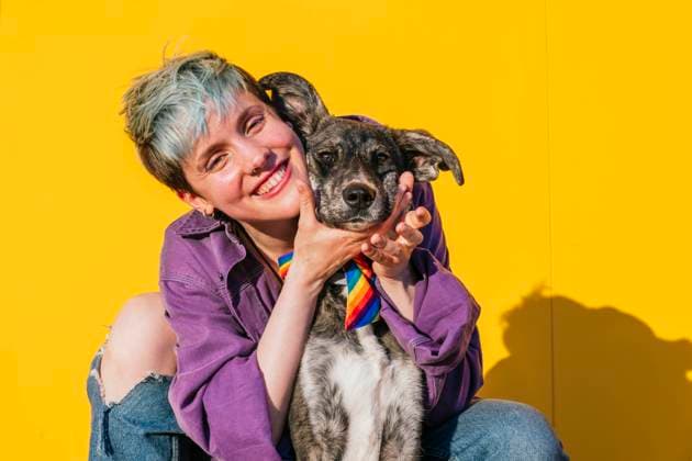 Happy lesbian woman with dog in front of yellow wall model released, Symbolfoto property released, MGRF00958
