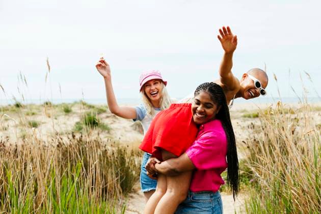 Creative Highlights Symbolbilder Smiling woman carrying friend on shoulder in field model released, Symbolfoto, EBSF03320