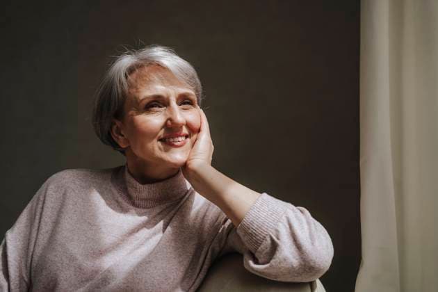 Mature woman sitting and smiling at home model released, Symbolfoto property released, MDOF01130