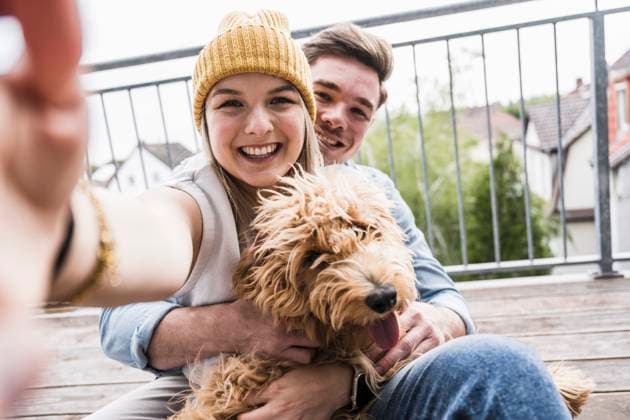 Happy woman taking selfie with man and dog on balcony model released, Symbolfoto property released, UUF28809