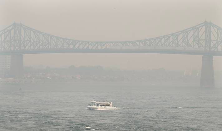 June 25, 2023, Montreal, PQ, Canada: A boat passes by the Jacques Cartier bridge obscured by a haze of smog in Montreal, Sunday, June 25, 2023, as a smog warning is in effect for the city and multiple regions of the province due to forest fires. Montreal Canada  - ZUMAc35_ 20230625_zaf_c35_022 Copyright: xGrahamxHughesx